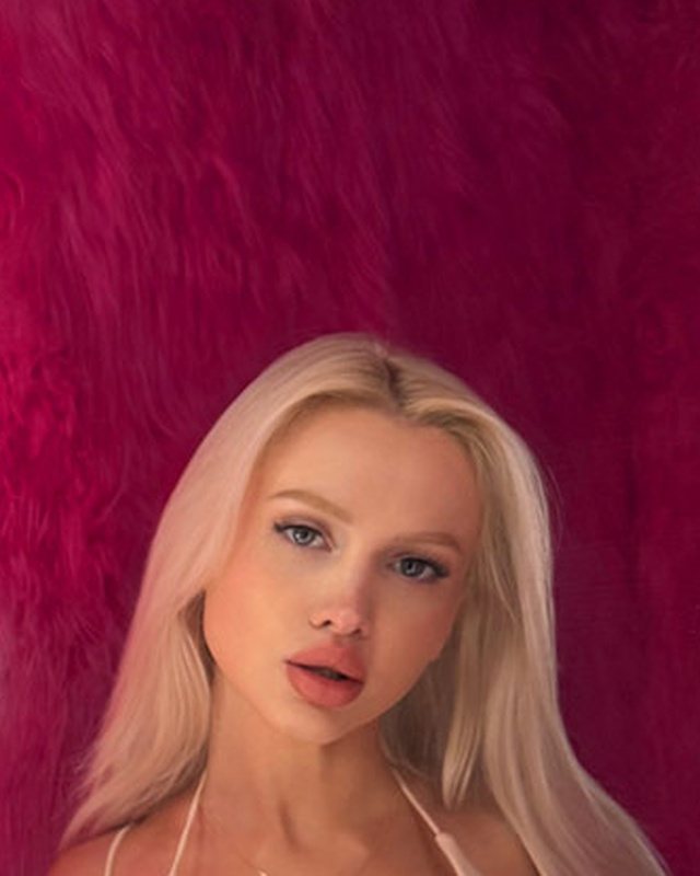 Bimbo aesthetic glow-up look: soft glam makeup, platinum hair and a pink lit background.
